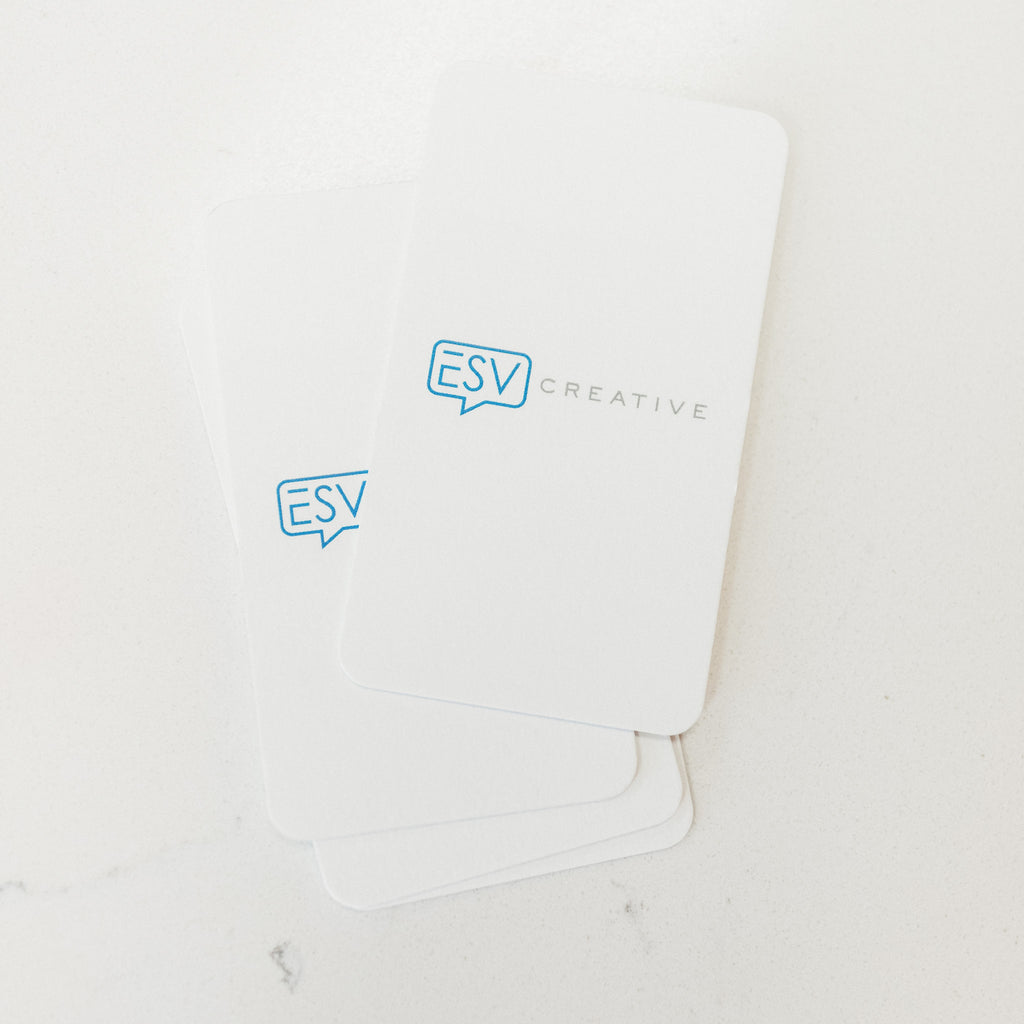Three ESV Creative gift cards with the logo "ESV Creative" in blue, fanned out on a white marble surface.